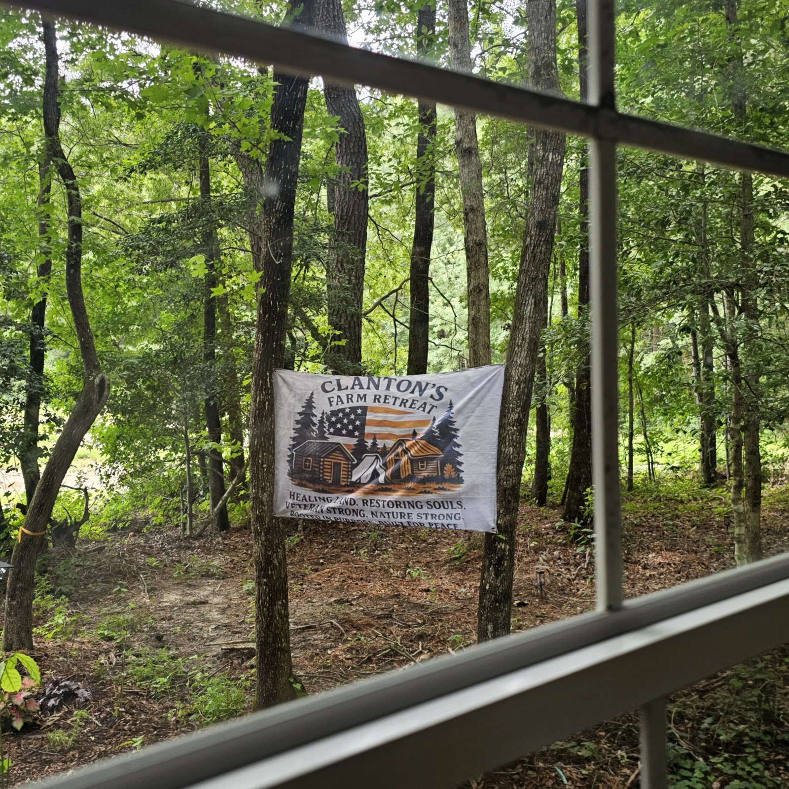 Clanton's Farm Retreat banner seen through the porch screen