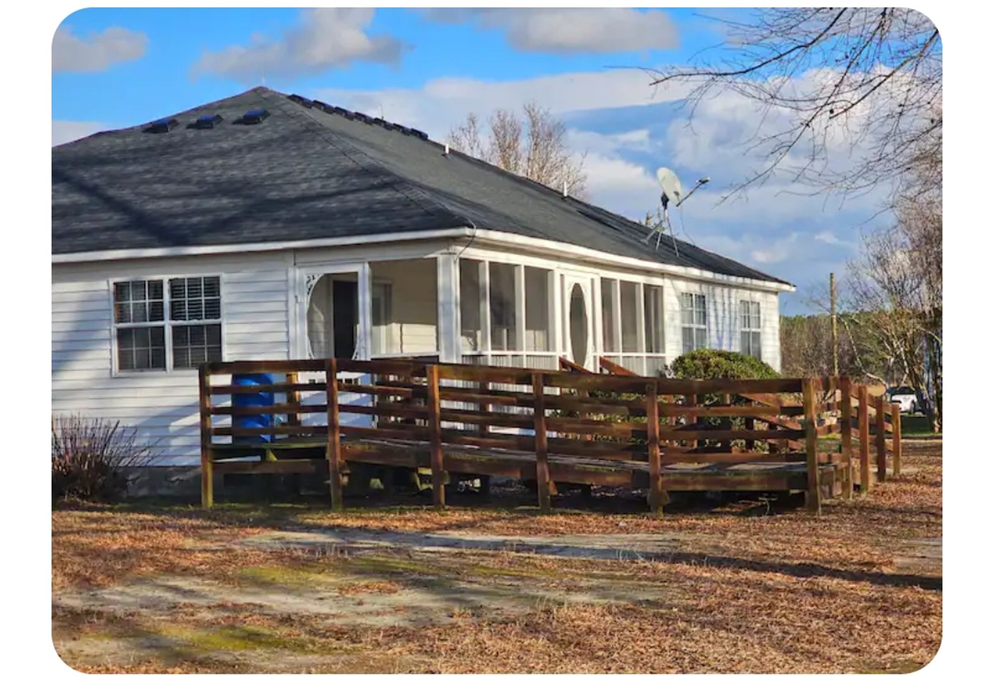 Exterior of the farmhouse with wraparound porch and accessibility ramp