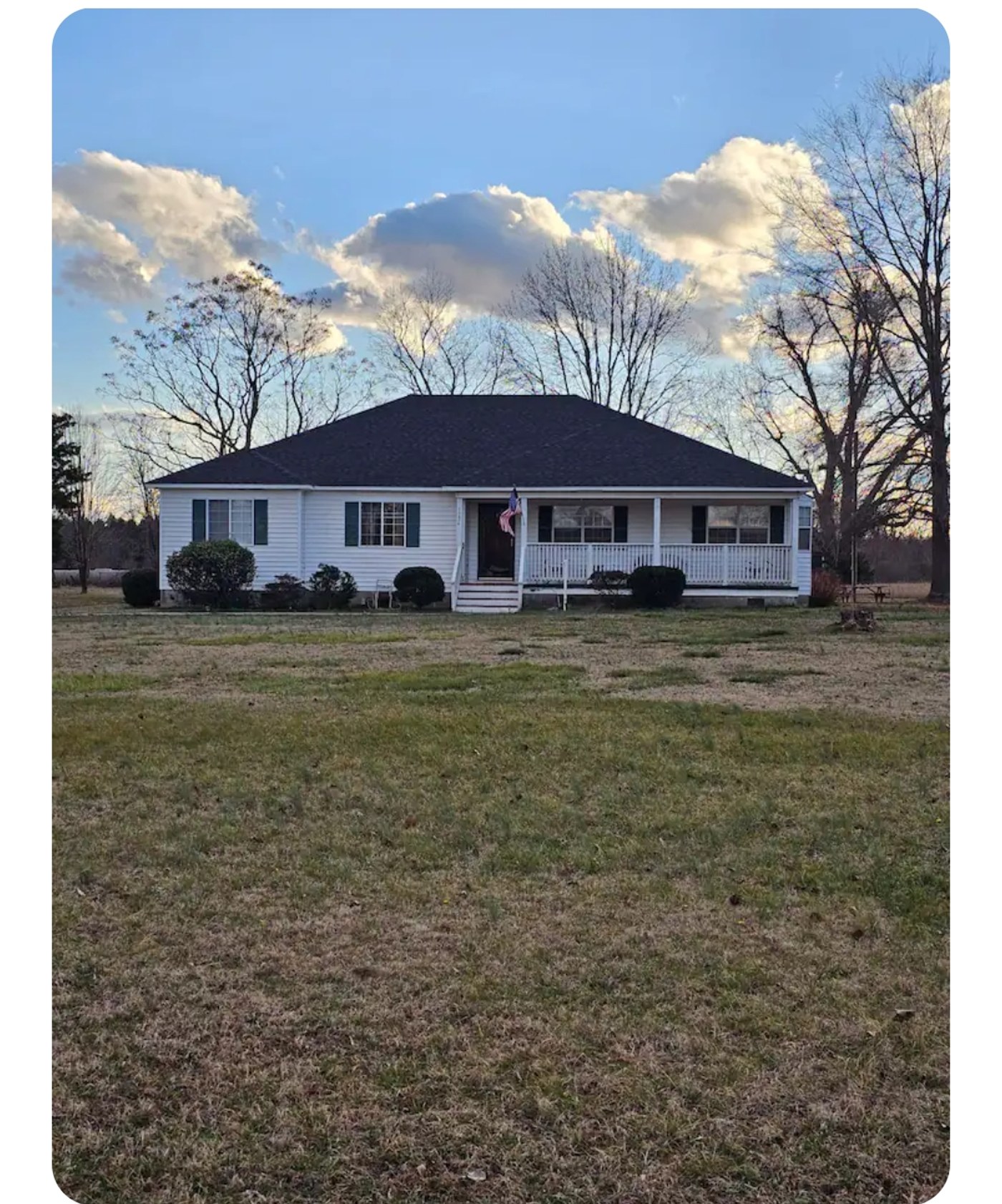 Clanton's Farm Retreat Farmhouse, a white ranch home with wraparound porch