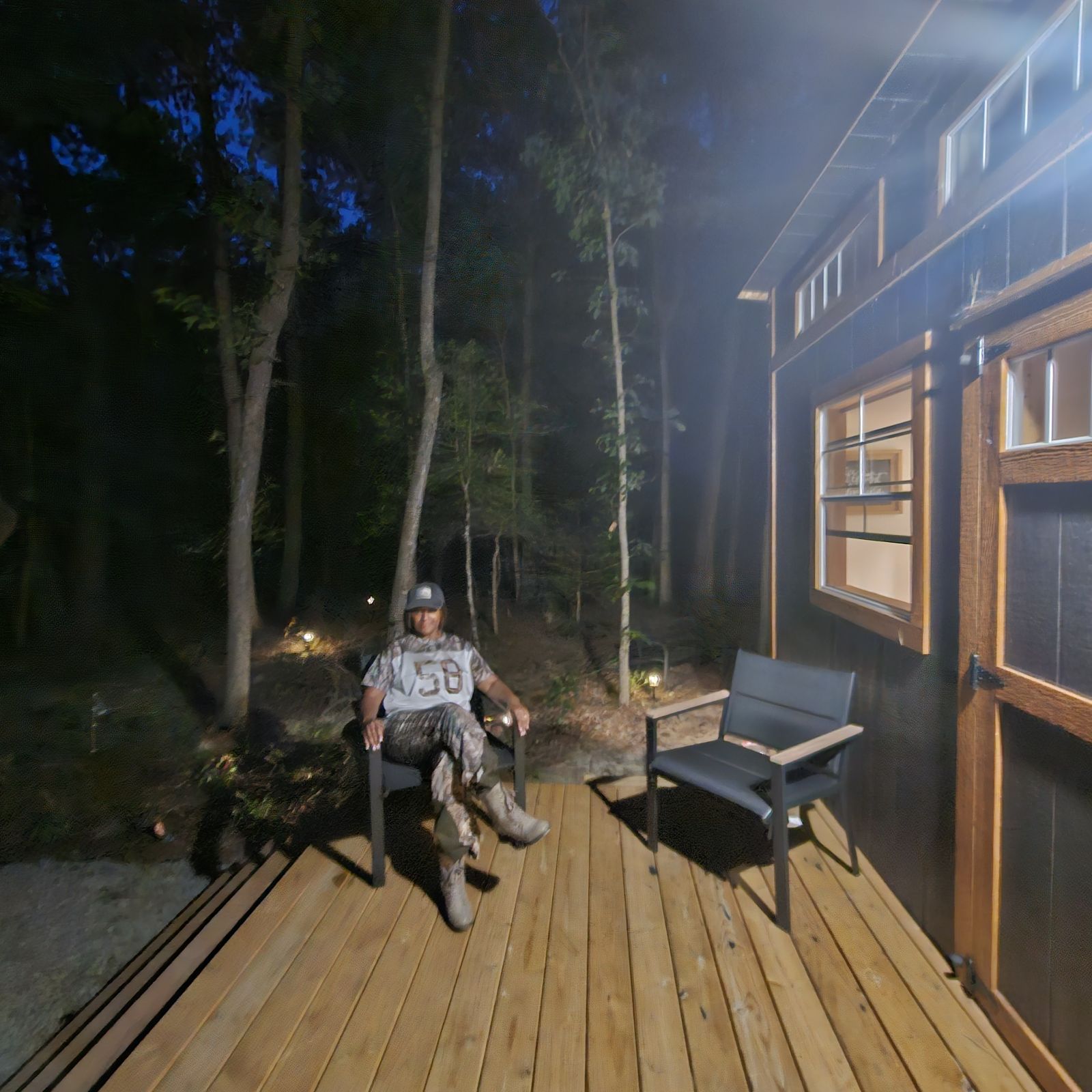 Guest relaxing on the cabin's front porch at dusk
